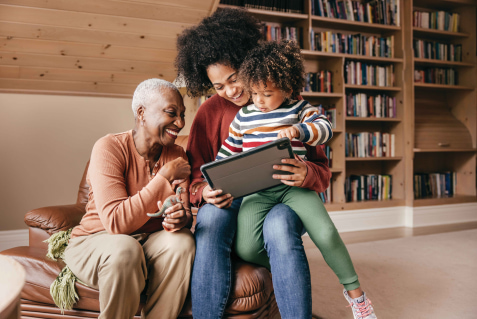 a person and two children looking at a tablet